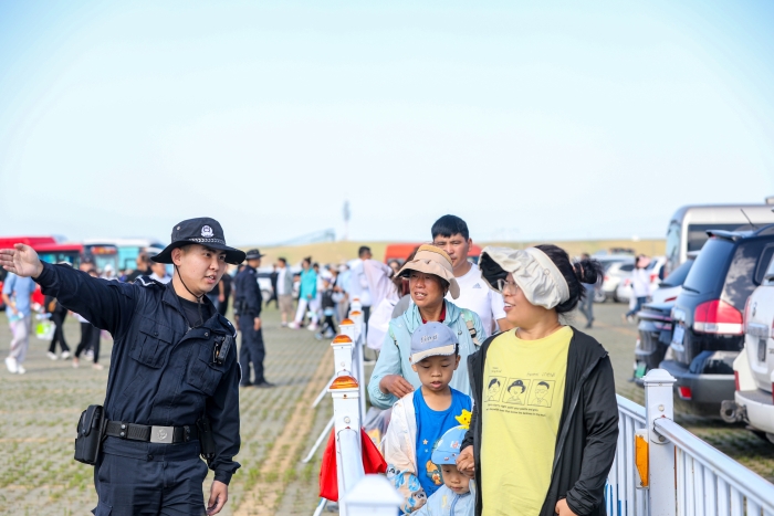 图三：7月16日，图为旅游节现场，民警正在服务引导游客。